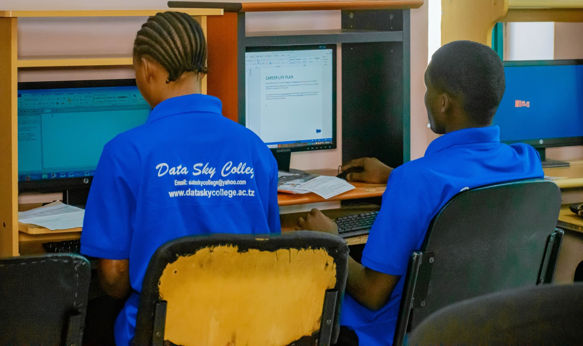 Two Datasky College students working together in a computer lab